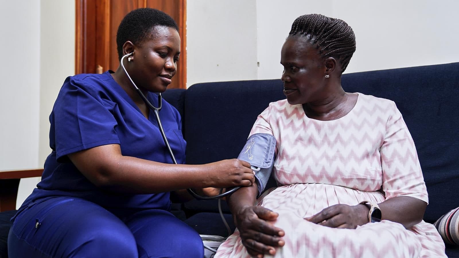 A caregiver assisting an elderly patient at home